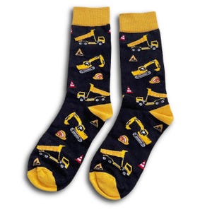 May include: A pair of black socks with yellow heels and toes. The socks are patterned with yellow construction vehicles, orange hard hats, and red and white traffic cones. The top of the socks are yellow.