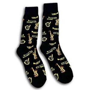 May include: Black socks featuring a repeating pattern of gold-coloured musical instruments, such as trumpets and saxophones. The socks are made from a soft material and are designed to fit a range of foot sizes.