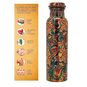 May include: A copper water bottle with a decorative paisley pattern in shades of green, red, and gold. The bottle has a matching lid. Text on the side panel lists health benefits of drinking water from a copper vessel.
