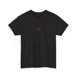 Puede incluir: Camiseta negra con la palabra "thriving" y un símbolo de cara sonriente rojo. La camiseta de manga corta tiene cuello redondo y está hecha de un material suave. El texto y el símbolo están en el pecho.
