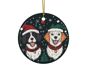May include: Round Christmas ornament featuring two dogs wearing Santa hats and red scarves. The dogs are smiling, and snowflakes and a small Christmas tree are in the background. The ornament has a gold string for hanging.