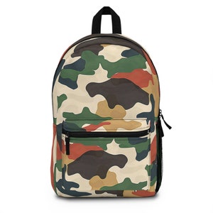 Könnte beinhalten: Ein Rucksack mit Camouflage-Muster in Beige, Grün, Braun und Rot. Er hat einen schwarzen Reißverschluss, eine seitliche Netztasche und einen schwarzen Griff. Der Rucksack hat eine Vordertasche mit einem schwarzen Reißverschluss.
