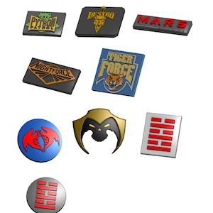 Puede incluir: Una colección de varios diseños de emblemas coloridos. Los emblemas incluyen textos como "PYTHON PATROL", "DESTRO", "MARS", "NIGHTFORCE" y "TIGER FORCE". Otros emblemas presentan una cobra, una cara con forma de calavera y un símbolo rojo y blanco.