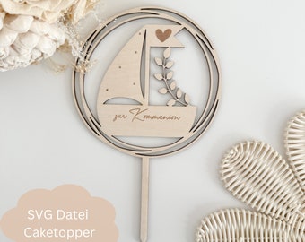 May include: Wooden cake topper with a sailboat design, a heart, and leaves. The topper is inscribed with the text "zur Kommunion".