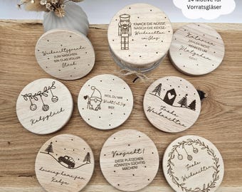 May include: Set of 10 round wooden Christmas jar lids with various designs and sayings. The lids feature a variety of Christmas themes, including a nutcracker, a gnome, a Christmas tree, and a wreath. The lids are perfect for adding a festive touch to your holiday decor.