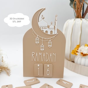 Könnte beinhalten: Ein beiger Ramadan-Countdown-Kalender mit Mond und Moschee-Design. Das Wort "Ramadan" ist in weißer Schrift dargestellt. Der Kalender hat zwei kleine Zahlenblöcke, die das Datum anzeigen. Der Text "3D Druckdatei STL 3MF" befindet sich in einer weißen Wolke.