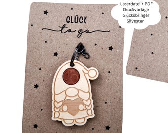 May include: A wooden gnome keychain with a coin in its head, attached to a metal ring. The gnome has a heart on its chest and is on a brown card with the words "Glück to go" and star designs.