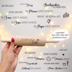 May include: A wooden rolling pin with the text "DIE GEHEIME ZUTAT IST: Liebe" and a heart symbol. The image also contains various German phrases and baking-related graphics, such as a cake and a whisk.