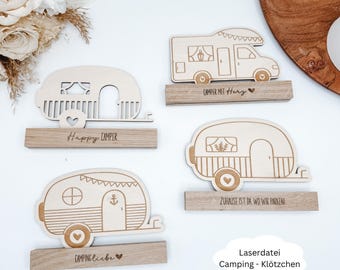 Può includere: Intagli in legno di camper e roulotte con testi come "Happy Camper" e "Camping Liebe". I disegni presentano ruote, finestre ed elementi decorativi. Gli intagli sono montati su basi di legno.