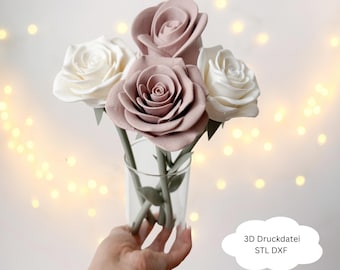 May include: A small glass vase holding a bouquet of artificial roses. The bouquet includes two white and two mauve-colored roses with green stems and leaves. The image has a soft, blurred background with bokeh lights.