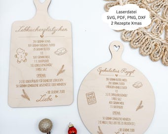 May include: Two wooden cutting boards with heart-shaped handles. One is rectangular and the other is round. Both boards feature engraved recipes for German Christmas cookies, with illustrations of ingredients and the word "Liebe".