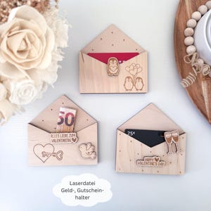 May include: Three wooden envelope-shaped gift card holders with laser-cut designs. The first holder has a penguin couple with balloons, the second has a key and a bird, and the third has a champagne glass and the text "Happy Valentine's Day".