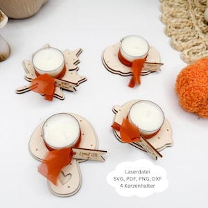 Op de afbeelding: Vier houten kaarshouders met waxinelichtjes, elk met een decoratief oranje lint en een kleine houten banner. De kaarshouders hebben verschillende vormen, waaronder een ster en een pompoen. De tekst op de afbeelding luidt "Laserdatei SVG, PDF, PNG, DXF 4 Kerzenhalter."