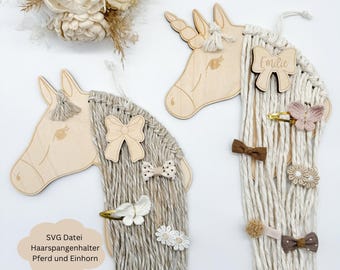 Könnte beinhalten: Holz-Haarspangenhalter in Form eines Pferdekopfes und eines Einhornkopfes mit beigefarbenem Garnhaar. Das Einhorn hat den Namen "Emilie" eingraviert.