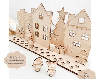 Puede incluir: Calendario de adviento navideño de madera con una escena de ciudad, que incluye casas, un árbol de Navidad y una farola. El calendario tiene 24 círculos numerados para colocar pequeños regalos o golosinas. El texto "SVG Datei Adventkalender/Countdowntafel" es visible en el calendario.
