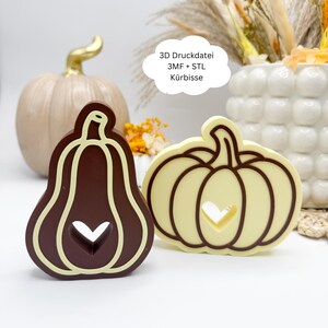 May include: Two pumpkin-shaped cookie cutters. One is dark brown with a light brown outline and a heart cutout. The other is light yellow with a dark brown outline and a heart cutout. A text bubble reads "3D Druckdatei 3MF + STL Kürbisse".