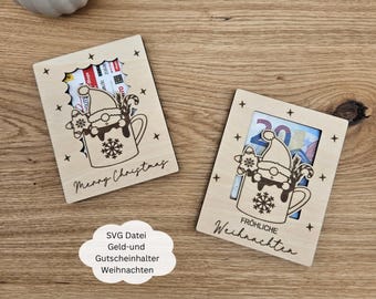 May include: Two wooden Christmas card holders with a cutout design of a snowman in a mug. The card holders have the text "Merry Christmas" and "Fröhliche Weihnachten" on them.
