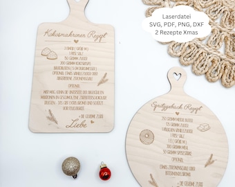May include: Two wooden cutting boards with recipes engraved on them. One is rectangular with a heart-shaped handle, the other is round. The text "Kokosmakronen Rezept" and "Spritzgeback Rezept" are visible. Decorative elements include wheat sprigs and the word "Liebe".