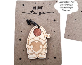 May include: A wooden gnome-shaped keychain with a coin in its hat, attached to a brown card with the words "Glück to go" and star designs. The keychain has a heart-shaped design on its body.