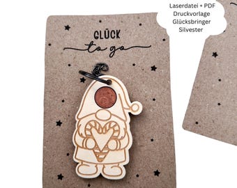 May include: A wooden gnome keychain with a coin embedded in its head, attached to a brown card with the words "Glück to go" and star designs. The gnome is holding a candy cane heart. The text "Laserdatei + PDF Druckvorlage Glücksbringer Silvester" is also present.
