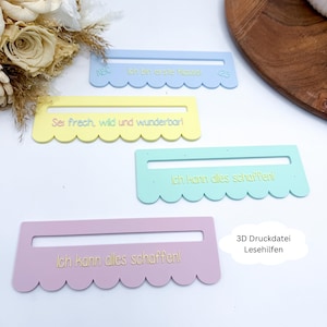 Può includere: Quattro ausili per la lettura dai colori pastello blu, giallo, verde e rosa. Ognuno ha un bordo smerlato e un'apertura rettangolare. Il testo in tedesco è stampato su ogni ausilio, con frasi come "Ich kann alles schaffen!"