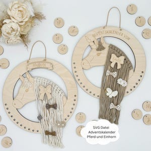 May include: Two wooden Advent calendars shaped like a horse and unicorn heads. Each calendar has a wooden ring with 24 numbered circles for hanging ornaments. The horse calendar has a white yarn mane and tail, while the unicorn calendar has a brown yarn mane and tail. Both calendars have the text "Adventkalender von" and a name, "Mustang" and "Emilie", respectively.