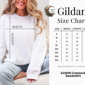 Może przedstawiać: Biała bluza dresowa Gildan z okrągłym dekoltem i tabelą rozmiar&oacute;w. Tabela zawiera wymiary w calach dla rozmiar&oacute;w od S do 5XL, w tym szerokość, długość i długość rękawa. Bluza to G18000.