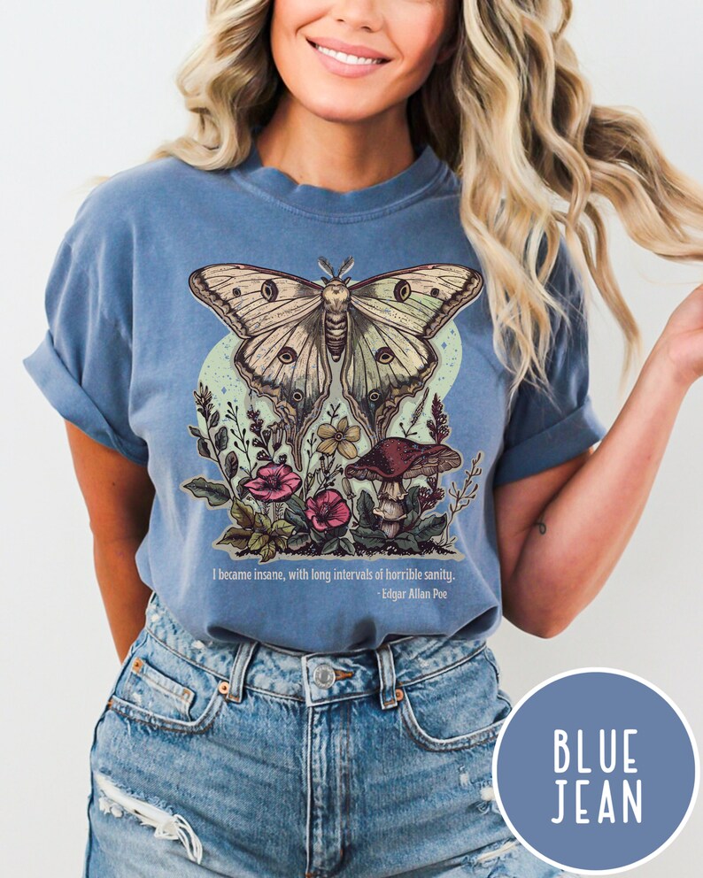 May include: A blue t-shirt featuring a green and white butterfly with brown accents, surrounded by flowers and a mushroom. The text "I became insane, with long intervals of horrible sanity. - Edgar Allan Poe" is printed below the graphic.