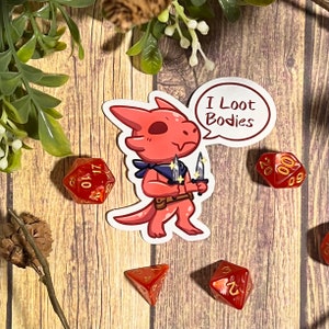 May include: A red cartoon dragon with a speech bubble that says "I Loot Bodies". The dragon is holding two daggers and is wearing a blue bandana. The dragon is on a wooden background with red dice.