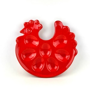 Peut inclure: Porte-œufs en céramique rouge en forme de poulet avec six indentations individuelles pour les œufs.