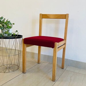 May include: A wooden chair with a red upholstered seat. The chair has a simple design with a straight back and four legs.