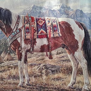 May include: A tapestry featuring a brown and white horse with a Native American saddle, standing in a landscape with teepees and mountains in the background. The horse is wearing a bridle and reins. The tapestry has a decorative border.