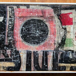 Può includere: Opera d'arte astratta a tecnica mista in una cornice bianca. La composizione presenta un grande quadrato rosso con un cerchio nero e un rettangolo rosso più piccolo. Linee e forme nere e bianche sono sovrapposte.