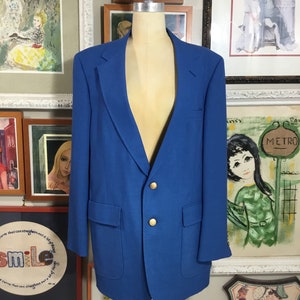 May include: A bright blue blazer with gold buttons. The blazer is made of a smooth, textured fabric.