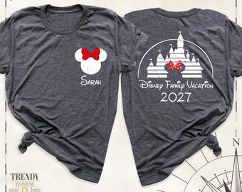 May include: A dark heather gray t-shirt shown from the front and back. The front features a white Minnie Mouse silhouette with a red bow and the name Sarah. The back displays a white castle graphic, a Minnie silhouette, and the text Disney Family Vacation 2027.