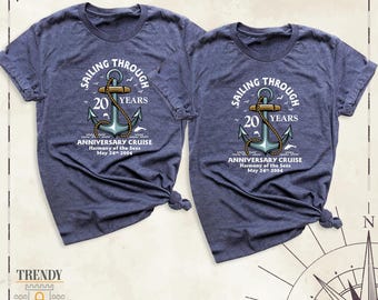 Puede incluir: Dos camisetas azul marino jaspeado con un gráfico de un ancla náutica envuelta en una cuerda. El texto dice SAILING THROUGH 20 YEARS ANNIVERSARY CRUISE Harmony of the Seas May 24th 2004. El diseño incluye pequeños pájaros y olas.