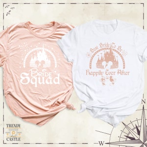Peut inclure: Deux t-shirts roses et blancs avec un motif du ch&acirc;teau de Cendrillon et le texte "Bride Squad" et "Best Bride To Be Happily Ever After".