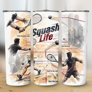 May include: A white tumbler featuring a watercolor illustration of squash players in action. The design includes the text "Squash Life" and action phrases like "Fast reactions only" and "Own the court". The tumbler is designed for sports enthusiasts.