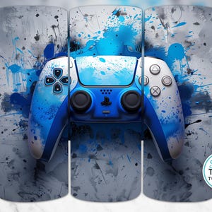 May include: A tumbler featuring a blue and white video game controller design. The controller is set against a backdrop of blue paint splatters and a gray, textured background. The tumbler has a glossy finish and is a gaming-themed product.
