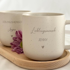 Hochwertiges Buchenholztablett mit individueller Namensgravur, kombiniert mit einer personalisierten Tasse. Handgefertigt, lebensmittelecht, mit Hartwachs behandelt. Pflegehinweise: nur von Hand waschen, trocken lagern, direkte Sonneneinstrahlung vermeiden. Wunderschön als Geschenk für besondere Menschen – Freundin, Frau, Kollegin oder für sich selbst. Steingut Tasse . Geschenk für Herzensmensch und Lieblingsmensch