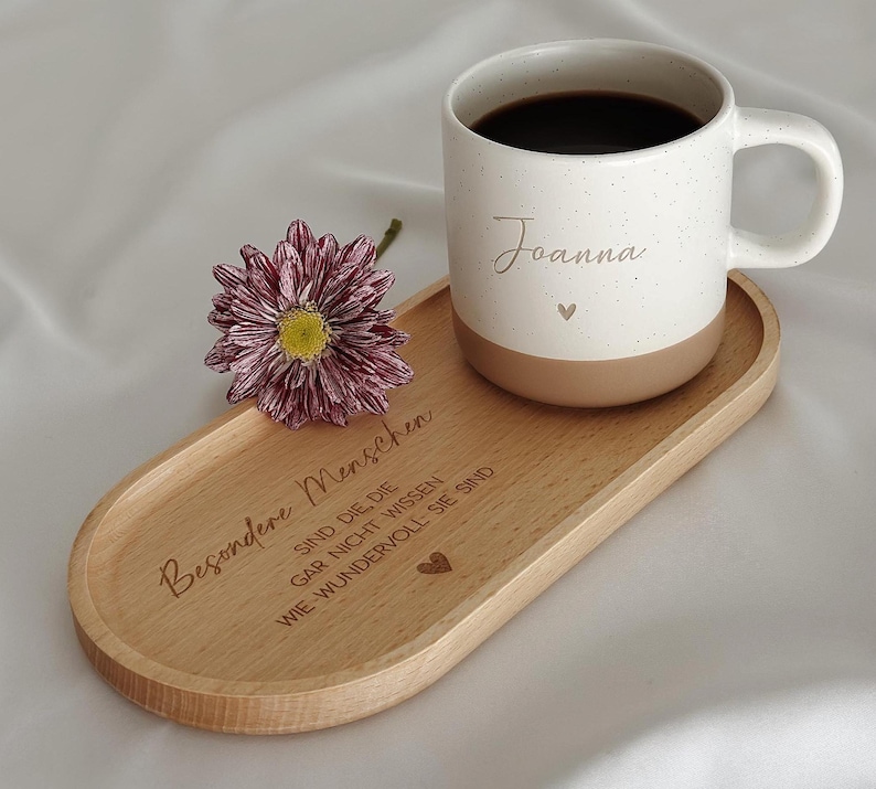 Keramiktasse mit personalisierter Namensgravur, befüllt mit Kaffee – auf Tablett serviert. Beige Tasse mit matter Oberfläche und 360 ml Volumen, perfekt für den Start in den Tag. Geschenk für Kolleg:innen, Freund:innen oder Familie, ideal für Abschied oder als kleine Überraschung. Zeitloses Design, langlebig, spülmaschinengeeignet, liebevoll graviert und dekorativ. Steingut Tasse. Personalisierte Geschenke