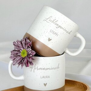Personalisierte Tasse mit Namen auf Holztablett, liebevoll dekoriert mit Schleifenband und Blume. Geschenkidee für Freundschaft, Familie oder zum Abschied. Ideal für Geburtstage, Weihnachten, Nikolaus oder Ostern. Rustikaler Stil in warmen Beige-Tönen, ein echter Blickfang im Alltag. Geschenkset für Kaffee- und Teeliebhaber:innen mit individueller Gravur und natürlicher Ästhetik. Steingut Tasse . Geschenk für Herzensmensch und Lieblingsmensch