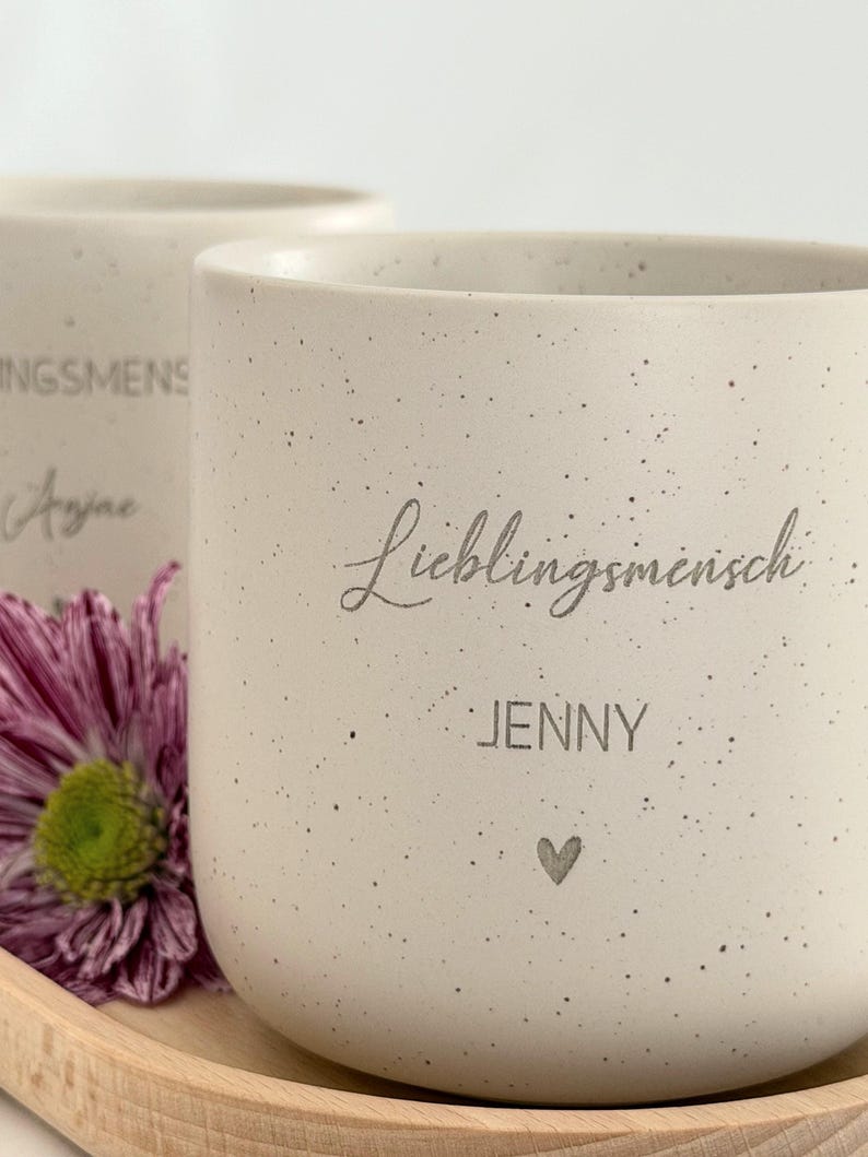 Obenansicht eines personalisierten Tassen-Sets: beige Keramiktasse mit Name auf graviertem Holztablett. Modernes, minimalistisches Design, perfekt als Geschenkidee für besondere Menschen.