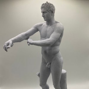Puede incluir: Una estatua blanca impresa en 3D de una figura masculina desnuda de pie sobre una base con un tocón de árbol. La figura está posada con un brazo extendido y la otra mano apoyada en el tocón.