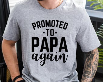 May include: Heather athletic grey t-shirt with the text "PROMOTED -TO- PAPA again" in black. The shirt is a crew neck style and is made of a soft, comfortable material.