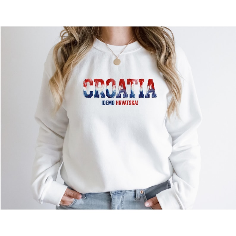 May include: White sweatshirt with the word "CROATIA" in red, white, and blue, with the text "IDEMO HRVATSKA!" below. The sweatshirt is a crew neck style.