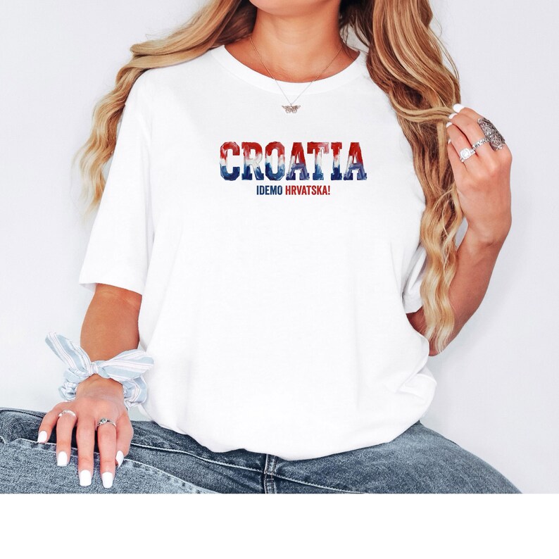 K&ouml;nnte beinhalten: Wei&szlig;es T-Shirt mit dem Wort "CROATIA" in Rot, Wei&szlig; und Blau und dem Text "IDEMO HRVATSKA!". Ein l&auml;ssiges T-Shirt f&uuml;r den Alltag.