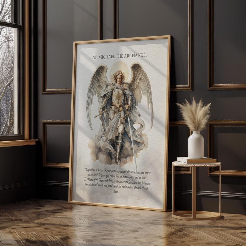 May include: A framed print featuring St. Michael the Archangel, depicted in detailed illustration. The artwork showcases the archangel in armor, holding a sword, with wings spread. The print includes text at the top and bottom, set in a gold-toned frame.