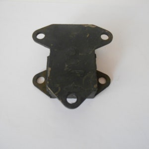 May include: Black metal engine mount with four holes. The mount is designed to support and isolate vibrations from an engine.