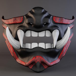 May include: A black and red Oni mask with large white fangs and teeth. The mask has a menacing expression, with red wood grain-like accents around the edges. The mask is a traditional Japanese demon mask.